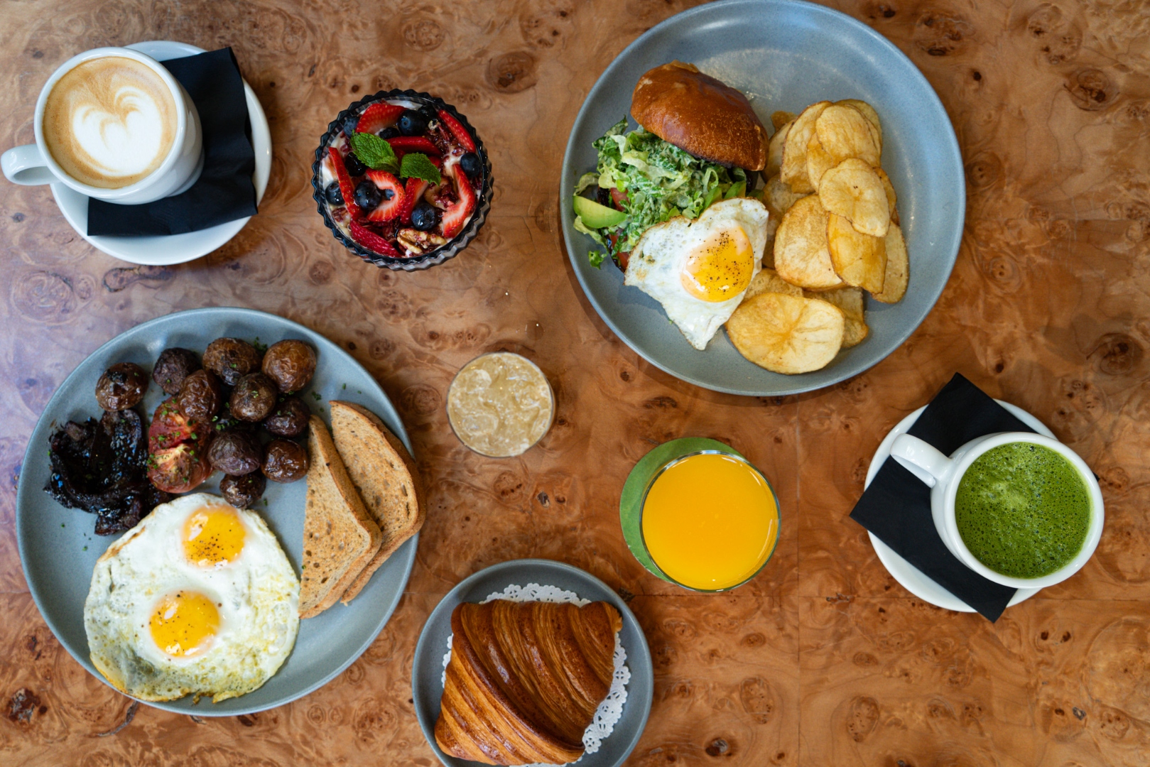 Breakfast spread with eggs, fruit, pastry, coffee, and juice