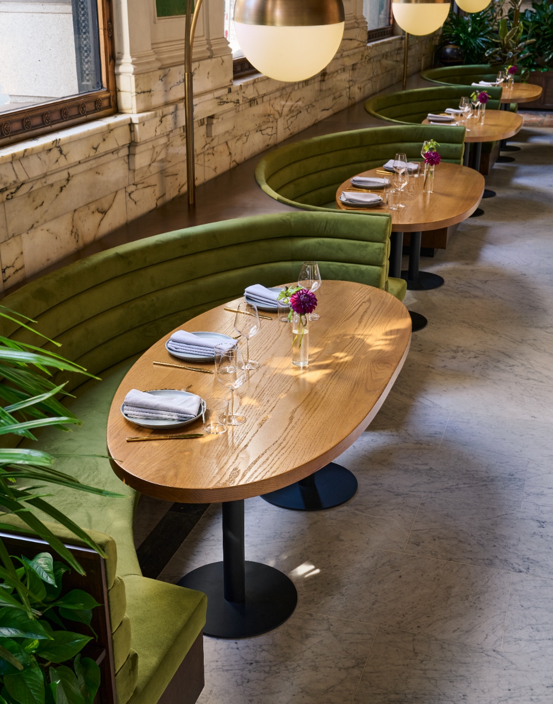 Green velvet café banquettes and tables